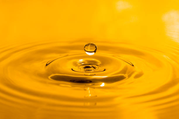 istock yellow drop oil , Liquid gold oil drop ripple background 1647793140