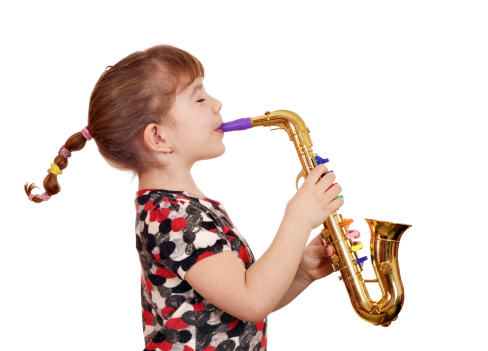 beautiful little girl play music on saxophone