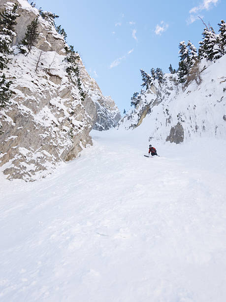 Off-piste skier in a steep chute stock photo