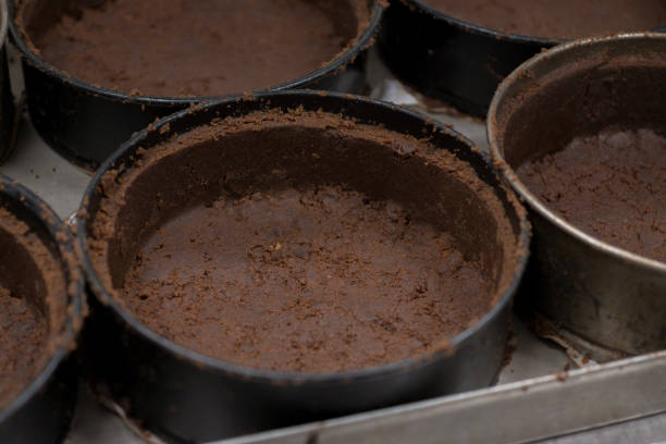 pastry chef preparing and baking stack of chocolate crust for salty caramel cheesecake