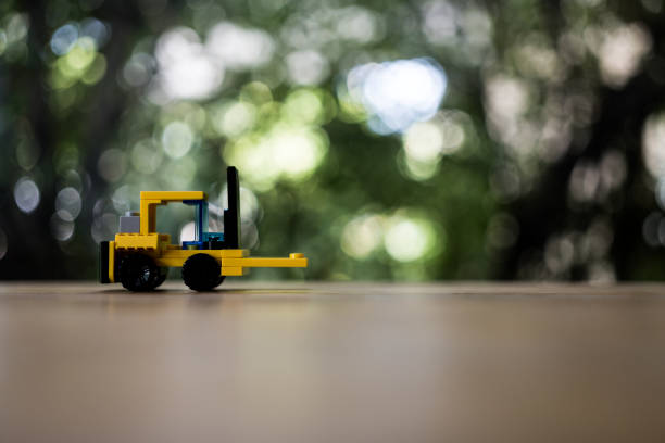 istock Yellow toy forklift loader on nature background with copy space for text. Logistics and industrial concept. 1647868901
