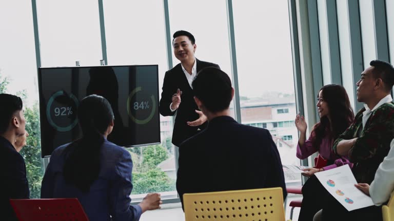 Asian businessman speaking to coworkers