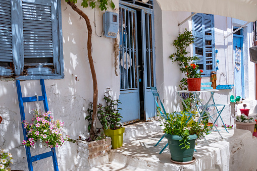Blue window with open wooden shutters on white painted wall of house in Amorgos, Greece.