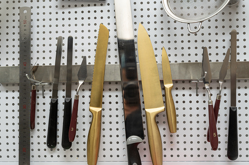 baking  cutting knives and tools hanging on the wall
