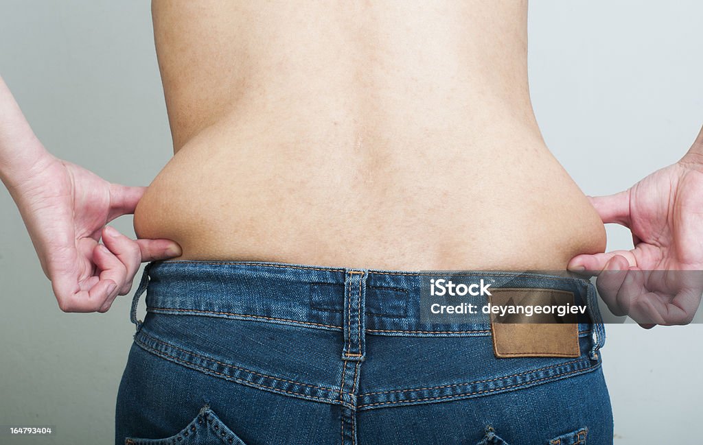 Woman pinching fat from her waist Woman pinching fat from her waist. Back shot Anatomy Stock Photo