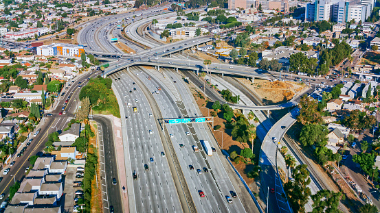 Aerial view of traffic driving on highway amidst neighbourhood in City Of Los Angeles, California, USA.