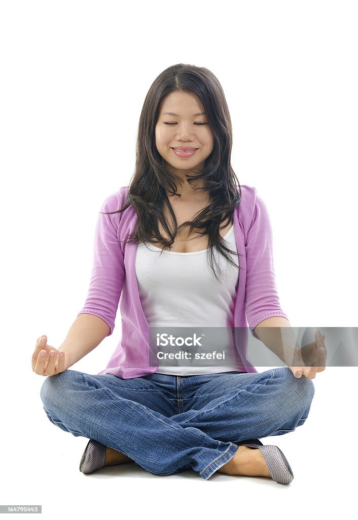 Calm Southeast Asian Chinese woman Calm Southeast Asian Chinese woman sitting in yoga lotus pose. Full body on white background. Adult Stock Photo