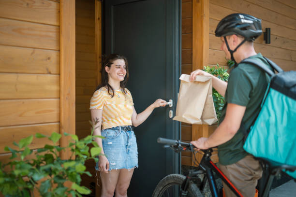 istock Woman taking food order from delivery guy. 1647979083