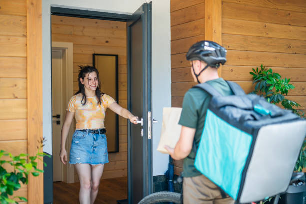 istock Woman taking food order from delivery guy. 1647979475