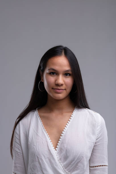 istock Young woman in a white cross over top posing smiling at camera 1647982967