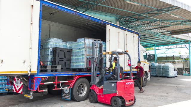 Product Delivery: Large container trucks prepare to deliver large quantities of bottled water to customers.
