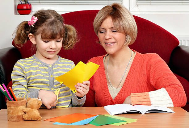 istock little girl cutting paper with scissors 164801715