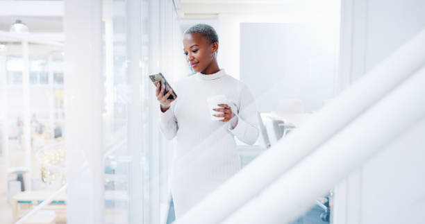 donna nera, telefono e risate per i social media, la comunicazione o gli sms presso l'ufficio aziendale. donna d'affari femminile afroamericana che sorride con lo smartphone mobile e chatta sul posto di lavoro - business blurred motion text messaging defocused foto e immagini stock