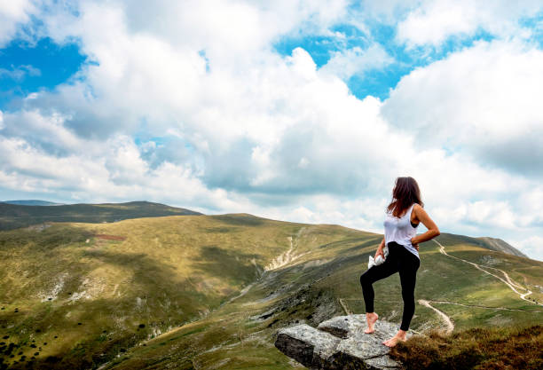 istock The young woman poses in a spectacular mountain setting. 1648022857
