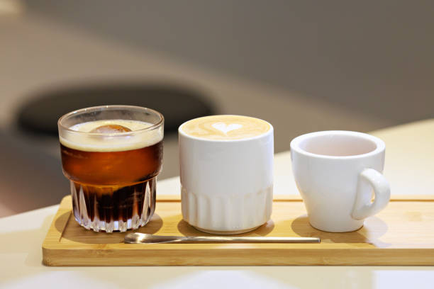 istock Close up a wooden tray holds three cups, each containing a unique coffee variant - espresso, latte, and ice black coffee 1648023930