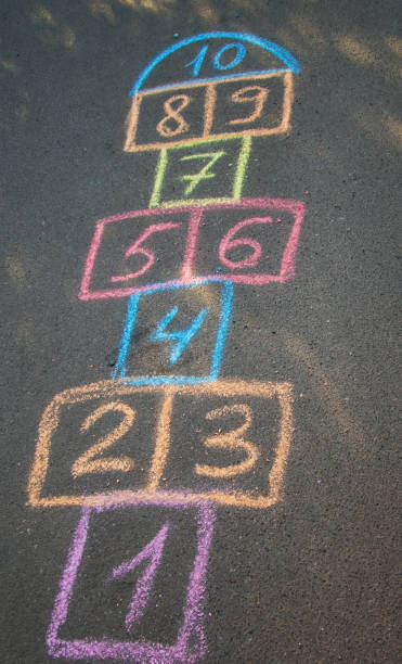 istock Backyard classics on an asphalt floor with chalk drawn numbers and squares. Selective focus 1648043087