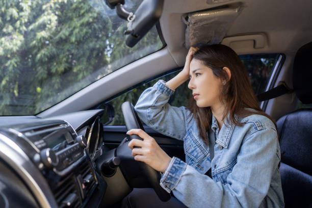 istock Asian woman with headache in a car 1648043650