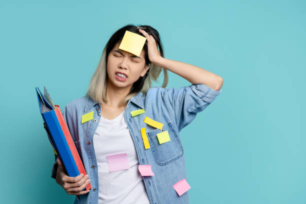 istock Puzzled office worker overloaded with paper work  isolated on light blue background. 1648046851