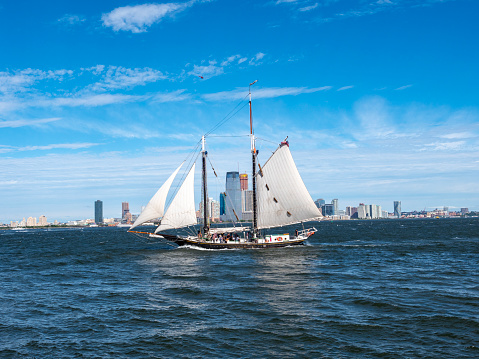 View of the New York City skyline, with sailboat in the Hudson River.