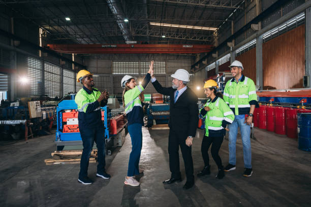 engenheiros de equipe e capatazes empilham a mão e apertam as mãos para mostrar sucesso nas máquinas da fábrica. trabalhadores da indústria se unem para colaborar. - encolher - fotografias e filmes do acervo