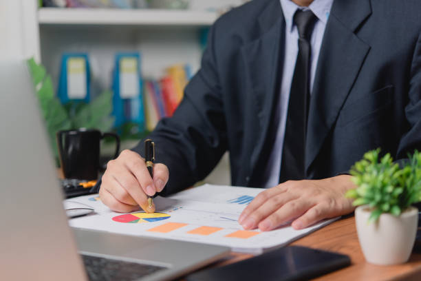 istock Businessman analysis investment data, charts accounting information, and develops financial and marketing reports using a laptop on his desk. 1648068055