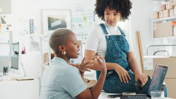 istock Warehouse, logistics and teamwork black women on laptop talking, discussion and conversation on e-commerce delivery system. Communication of delivery store girl workers planning stock online shipping 1648075170