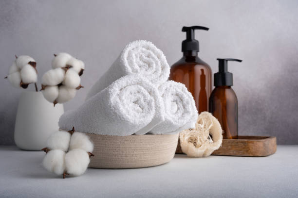 istock Stack of rolled white towels with cotton flowers and dispenser bottles 1648086551