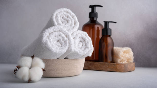 istock Stack of rolled white towels with cotton flowers and dispenser bottles 1648086553
