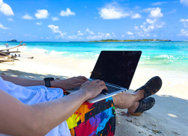istock Nomad digital with laptop and running remotely with bright scenic view near poolside on the beach in summer time 1648097767