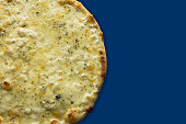 Close-up of pizza Quattro formaggi isolated on a blue background