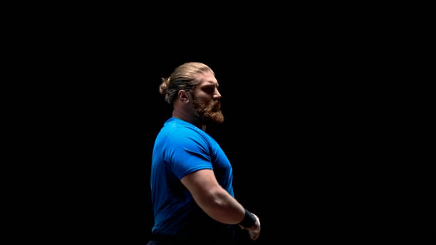Thoughtful male athlete looking away while standing outdoors at night.