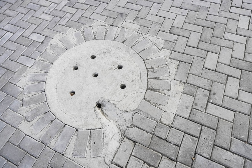 Cement water drainage holes installed in paving block areas to reduce the volume of rainwater on the streets. Concept for protection flood mitigation, architecture, water flow system, plumbing.