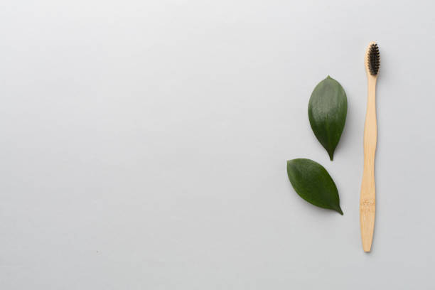 istock Toothbrush with green leaves color on background. Top view 1648152642