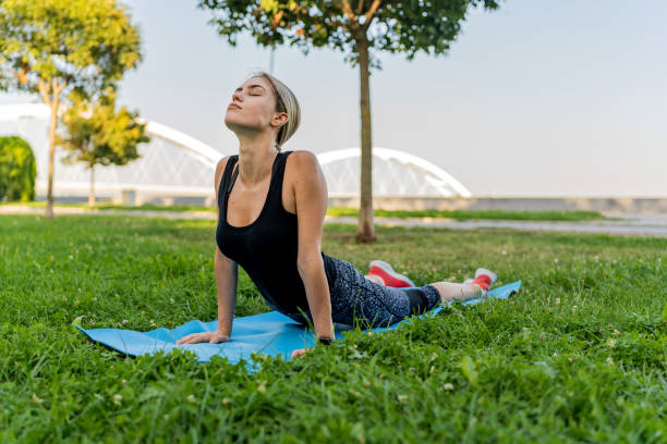 istock Young woman works out on exercise mat in the open 1648162698
