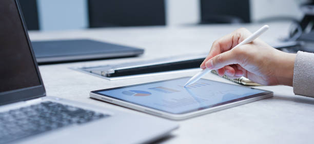 istock close up manager man hand use stylus pencil to point chart report dashboard on digital tablet for checking about financial and profit of company yearly for business lifestyle concept 1648169734