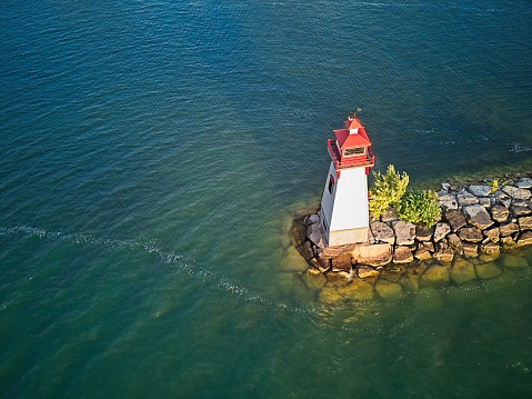 Aerial View of a Lighthouse at a Marina in a Small Town during Sunrise