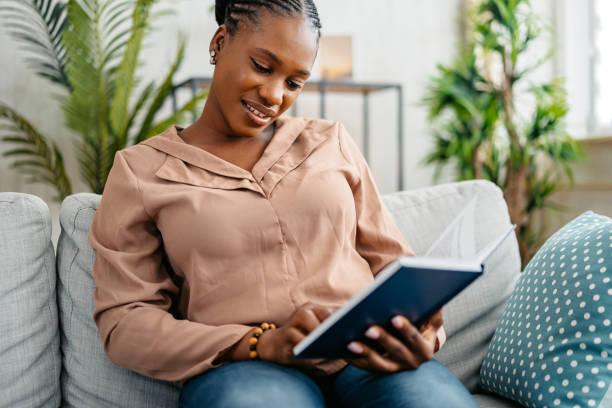 istock Young Woman Reading A Book At Home 1648180247