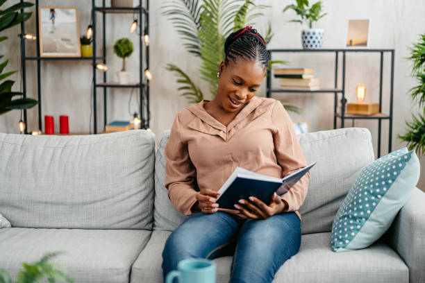 istock Young Woman Reading A Book At Home 1648185111