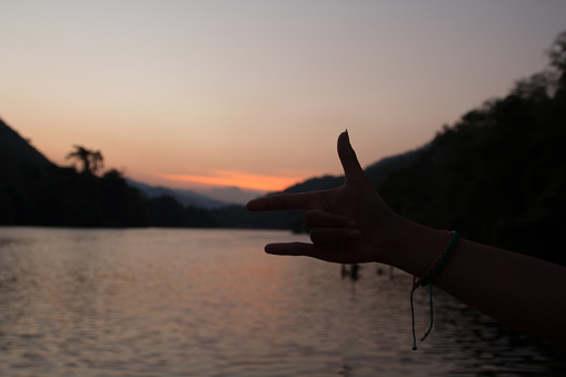 Three finger symbol The mother finger, the index finger and the little finger symbolize love and peace on the mountains, rivers and the blue background is a land full of tourists.