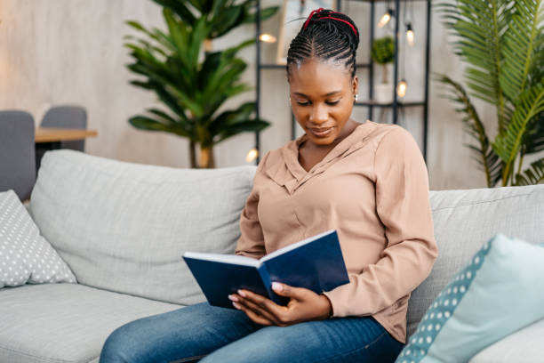 istock Young Woman Reading A Book At Home 1648189156