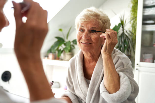 istock Senior woman doing eye make up in the bathroom 1648190212