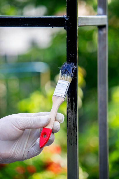 istock a man paints metal with black paint with a brush 1648191564