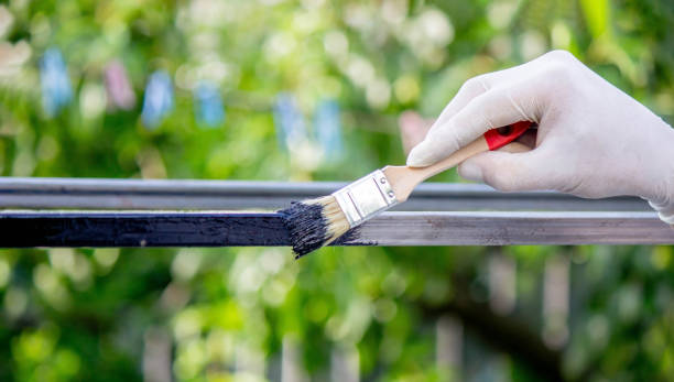 istock a man paints metal with black paint with a brush 1648191571