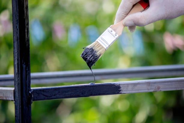 istock a man paints metal with black paint with a brush 1648191574