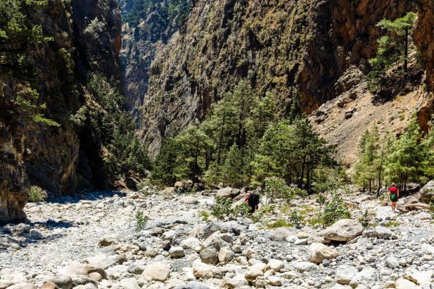 istock Hikers in a narrow gorge with huge, towering cliffs either side (Samaria Gorge, Greece) 1648191715