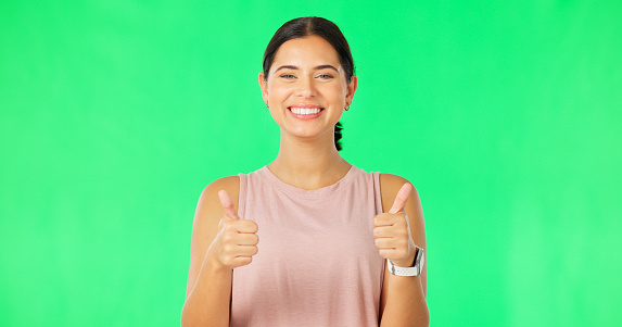 Happy woman, hands and thumbs up on green screen for fitness, agreement or winning against a studio background. Portrait of sporty female showing thumb emoji, yes sign or like for good job on mockup