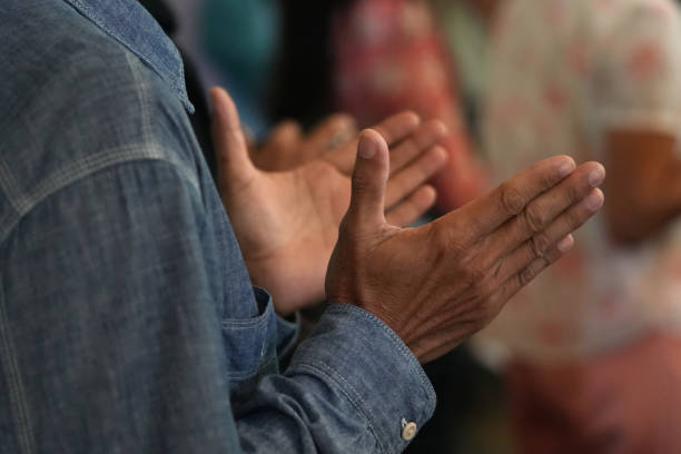istock Human hands praying rising together at Church. 1648195575