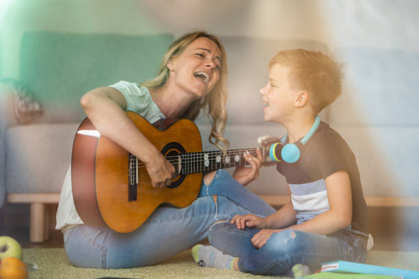 istock Woman playing guitar and singing whit her son at home 1648207105