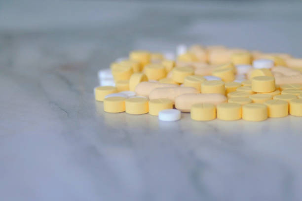 istock many yellow and white pills together on a white table 1648218826