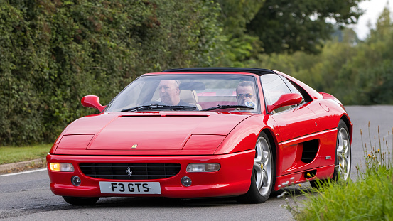 Whittlebury,Northants,UK -Aug 27th 2023: 1999 red Ferrari 355 car travelling on an English country road